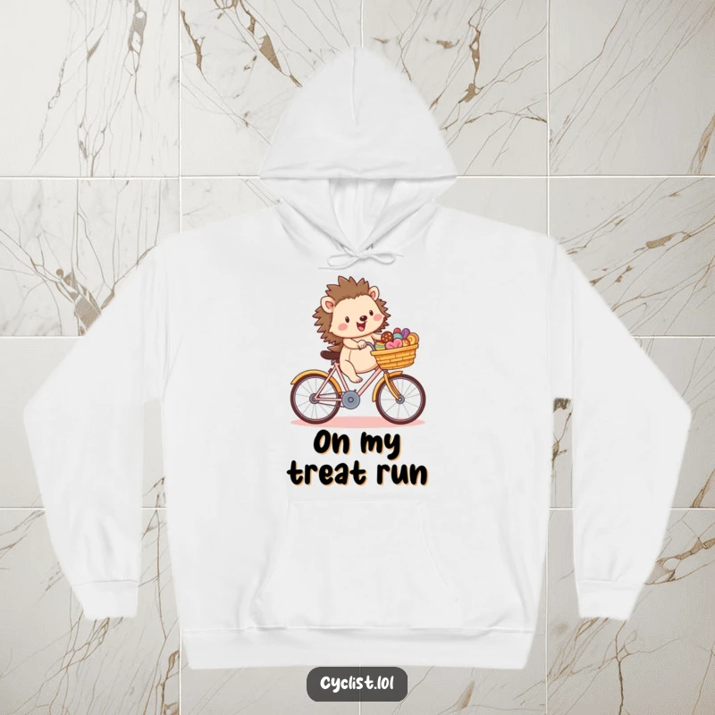 Funny hedgehog character joyfully riding a bicycle with a basket full of treats, featured on a comfortable hoodie, for cozy and cheerful wear.