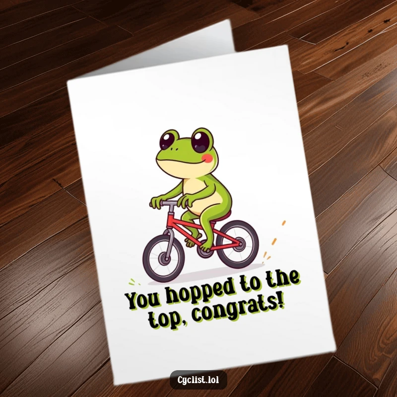 Funny free printable congratulations card showing a playful frog expertly navigating tiny obstacles on a bike.