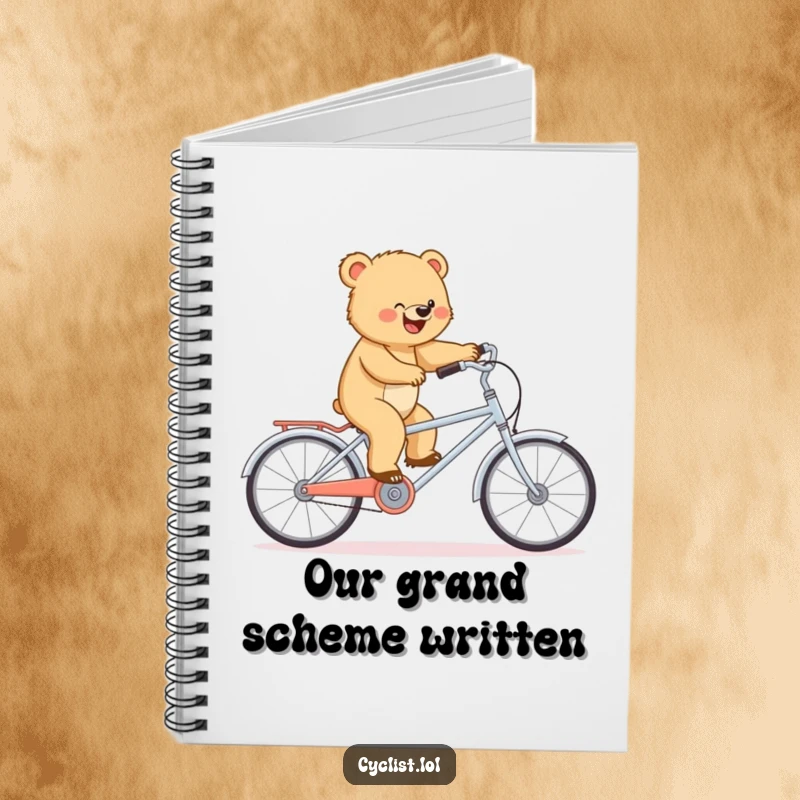 Funny notebook cover featuring a determined bear cub balancing on a miniature tandem bike, inspiring focused note-taking.