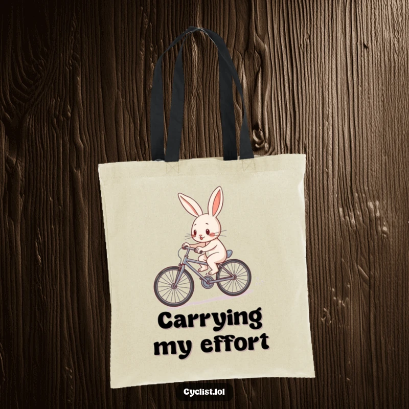 Funny determined rabbit character pedaling a tiny bicycle uphill on a tote bag, showcasing effort and a strong will.